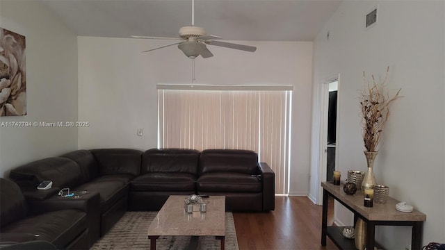 living room featuring dark wood-type flooring and ceiling fan