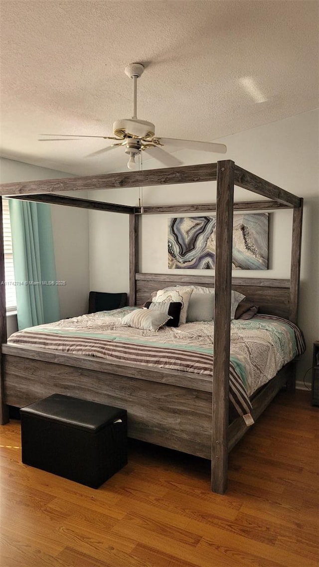 bedroom with hardwood / wood-style floors, a textured ceiling, and ceiling fan