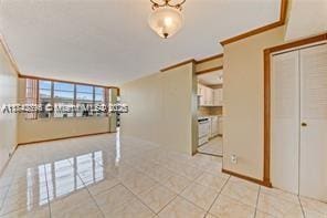 empty room featuring light tile patterned floors and ornamental molding