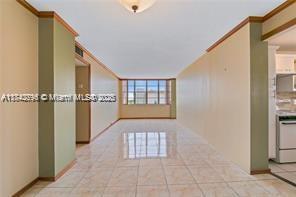 corridor featuring crown molding and light tile patterned flooring