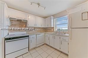 kitchen with white appliances, sink, light tile patterned floors, and white cabinets