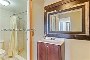 bathroom featuring walk in shower, vanity, and toilet