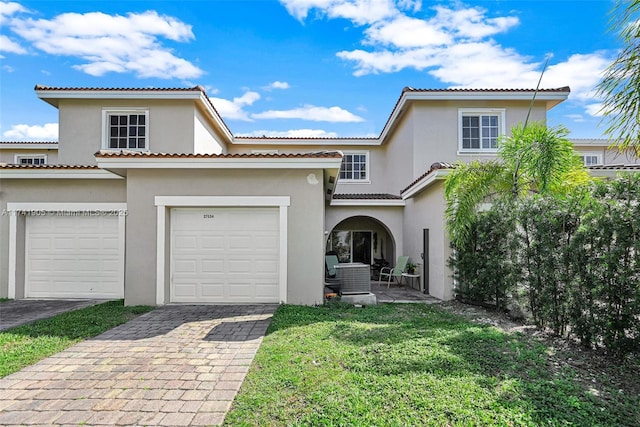 mediterranean / spanish home featuring a garage and a front yard