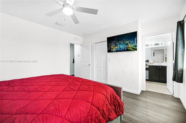 bedroom featuring hardwood / wood-style floors, ensuite bath, and ceiling fan