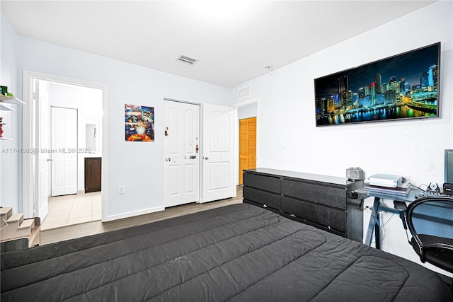 bedroom featuring connected bathroom, hardwood / wood-style floors, and a closet