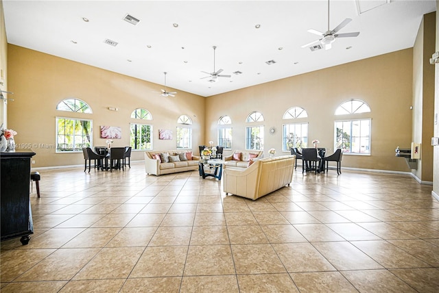 living room featuring light tile patterned flooring, ceiling fan, and plenty of natural light