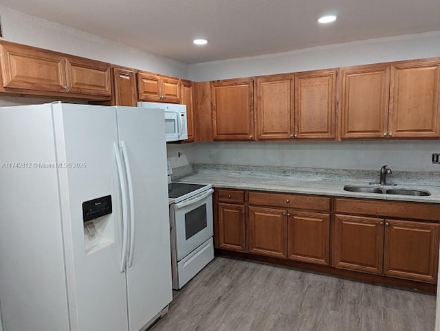 kitchen featuring sink, white appliances, and light hardwood / wood-style flooring