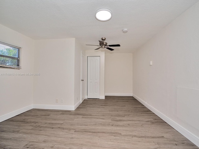 spare room featuring ceiling fan, a textured ceiling, and light wood-type flooring