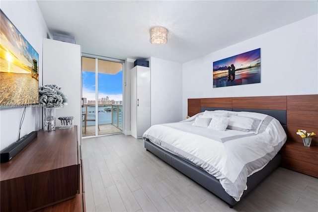 3330 NE 190th St Unit 1715, Aventura, FL 33180 - bedroom with wood finished floors, access to exterior, and a wall of windows