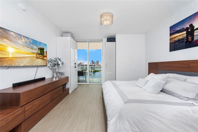3330 NE 190th St Unit 1715, Aventura, FL 33180 - bedroom featuring access to exterior, light wood-style flooring, and a wall of windows