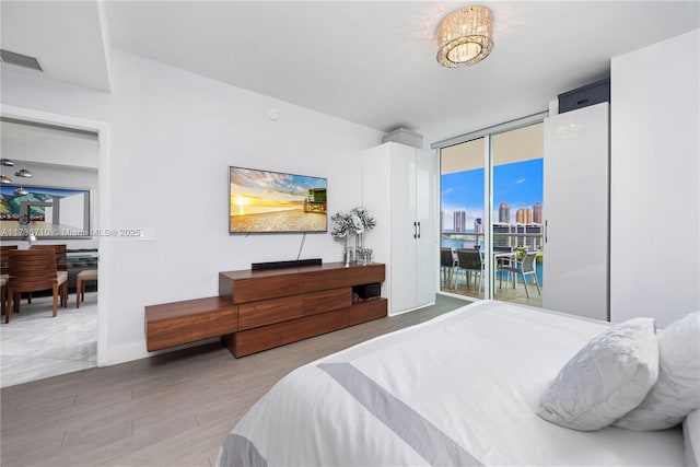 3330 NE 190th St Unit 1715, Aventura, FL 33180 - bedroom with access to exterior, wood finished floors, and a wall of windows