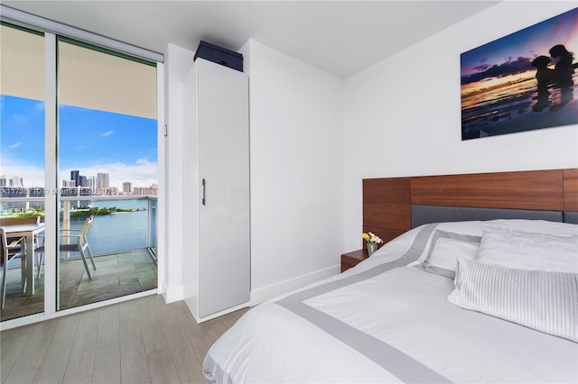 3330 NE 190th St Unit 1715, Aventura, FL 33180 - bedroom with wood finished floors, a city view, expansive windows, access to outside, and baseboards