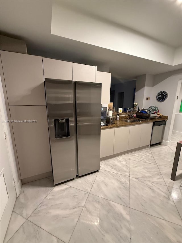3330 NE 190th St Unit 1715, Aventura, FL 33180 - kitchen with stainless steel appliances, light marble finish flooring, white cabinetry, baseboards, and dark stone countertops