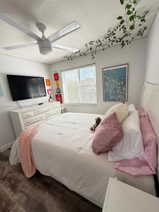 bedroom featuring ceiling fan, dark wood-type flooring, and a textured ceiling