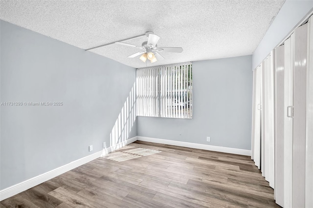 spare room featuring a textured ceiling, ceiling fan, and wood-type flooring