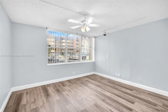 empty room featuring a textured ceiling, ceiling fan, and light hardwood / wood-style flooring