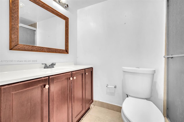 bathroom featuring tile patterned floors, toilet, vanity, and an enclosed shower