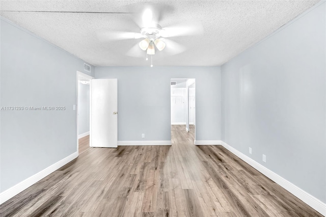 spare room with a textured ceiling, hardwood / wood-style flooring, and ceiling fan