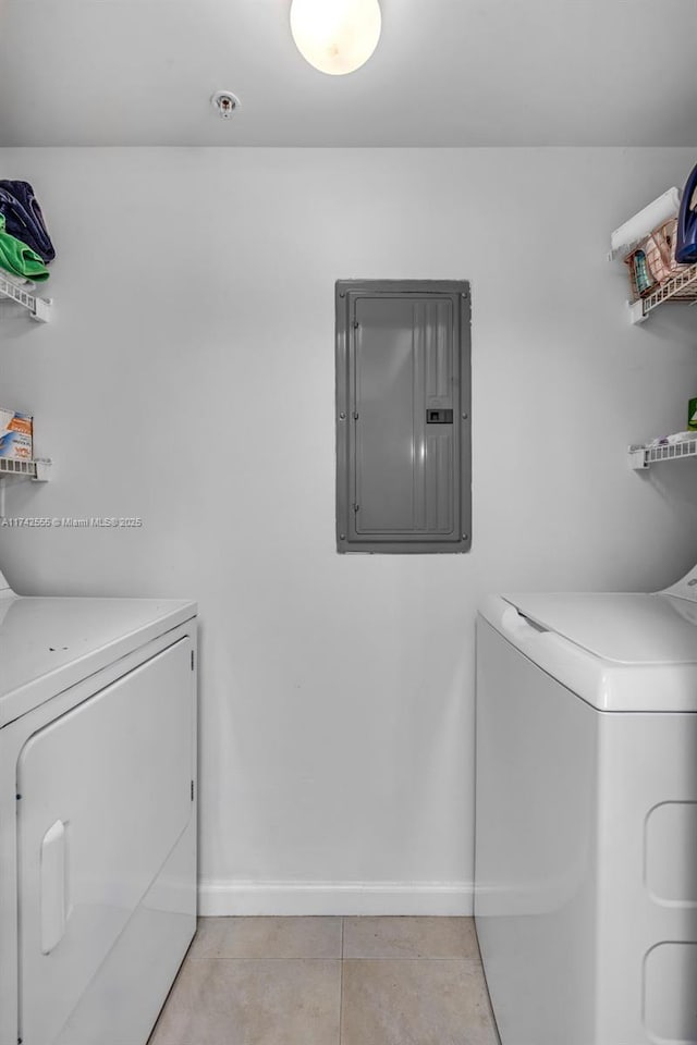 washroom with light tile patterned flooring, electric panel, and washer and clothes dryer