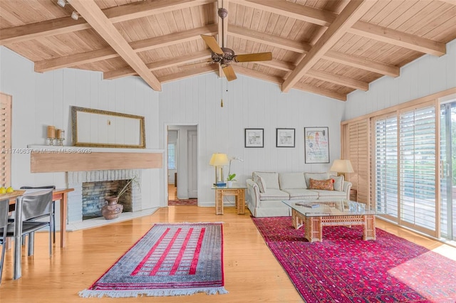 living room featuring a brick fireplace, vaulted ceiling with beams, wooden ceiling, and light wood-type flooring