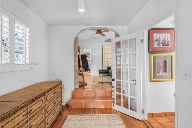 stairs with hardwood / wood-style flooring and ceiling fan