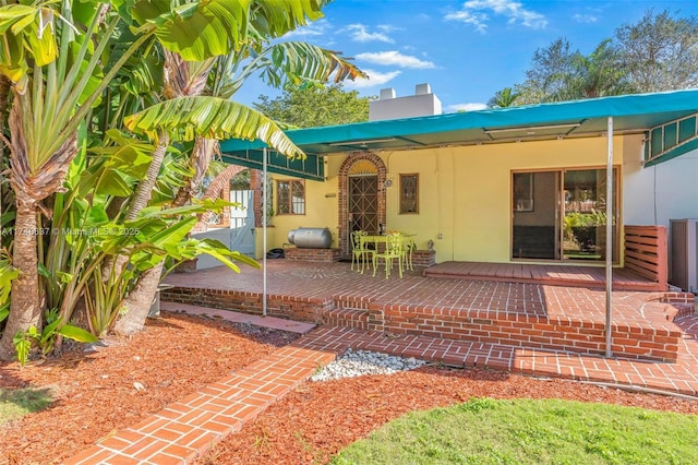 view of exterior entry featuring a patio area