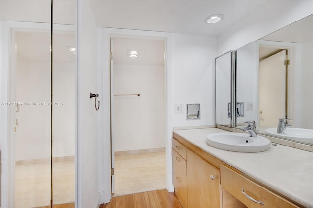 bathroom featuring recessed lighting, wood finished floors, and vanity