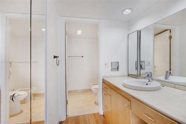 full bathroom featuring wood finished floors, vanity, toilet, and recessed lighting