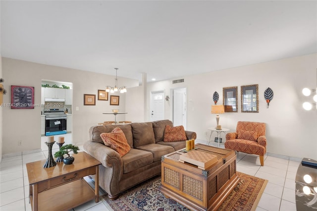 living area with visible vents, a notable chandelier, baseboards, and light tile patterned floors