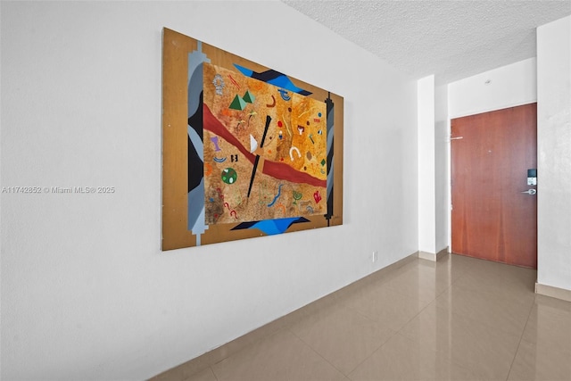 corridor featuring tile patterned flooring and a textured ceiling