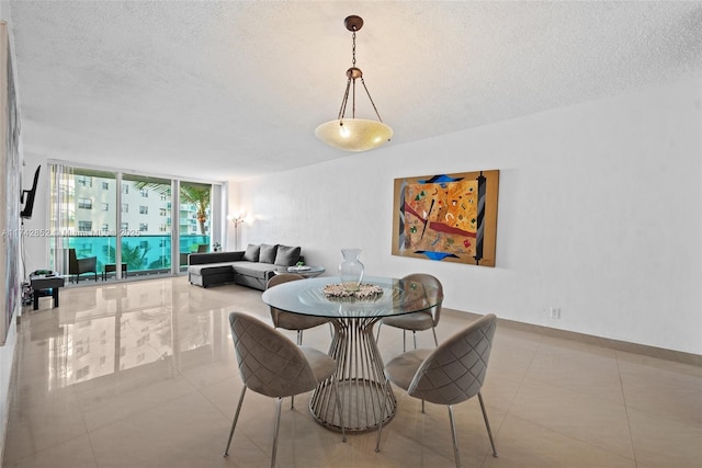 dining space featuring expansive windows, light tile patterned floors, a textured ceiling, and baseboards