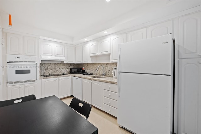 kitchen with under cabinet range hood, a sink, white cabinetry, black appliances, and tasteful backsplash