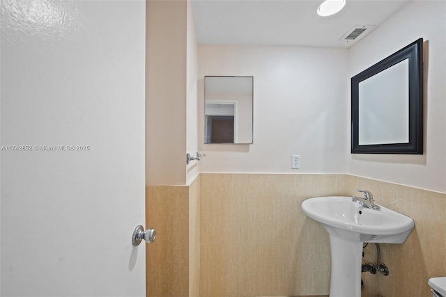 bathroom featuring a wainscoted wall and visible vents