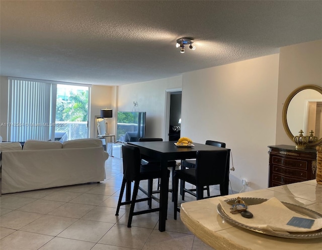 dining area featuring a textured ceiling and light tile patterned floors