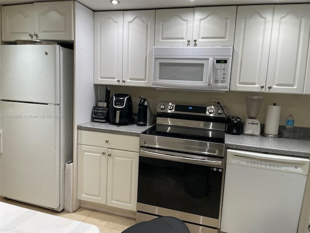 kitchen with light countertops, white appliances, white cabinetry, and light tile patterned floors