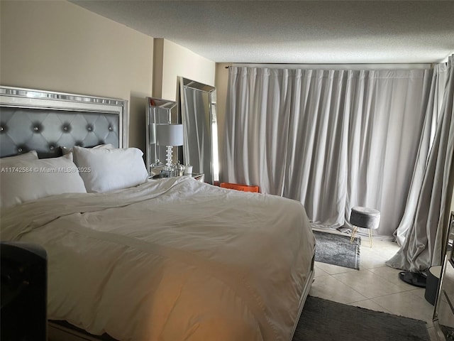 bedroom with light tile patterned floors and a textured ceiling