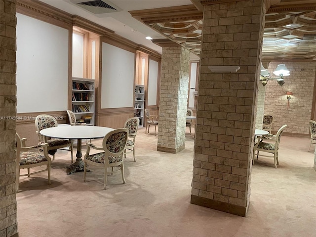 wine cellar featuring a wainscoted wall, visible vents, light carpet, brick wall, and coffered ceiling