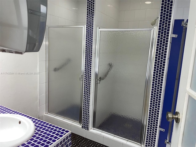 bathroom featuring a sink and a shower stall