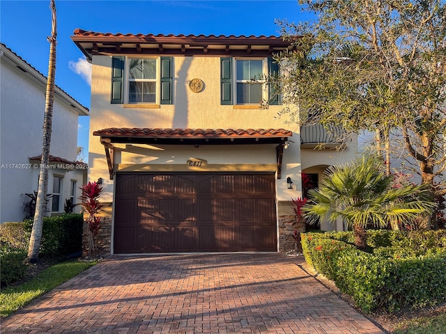 6411 Osprey Landing St, Davie, FL 33314 - mediterranean / spanish house with a tile roof, an attached garage, decorative driveway, and stucco siding
