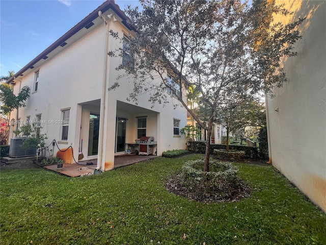6411 Osprey Landing St, Davie, FL 33314 - rear view of house featuring a yard, a patio, central AC unit, and stucco siding
