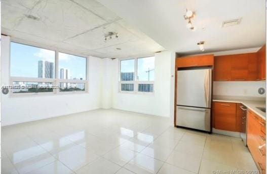 kitchen with fridge and light tile patterned flooring