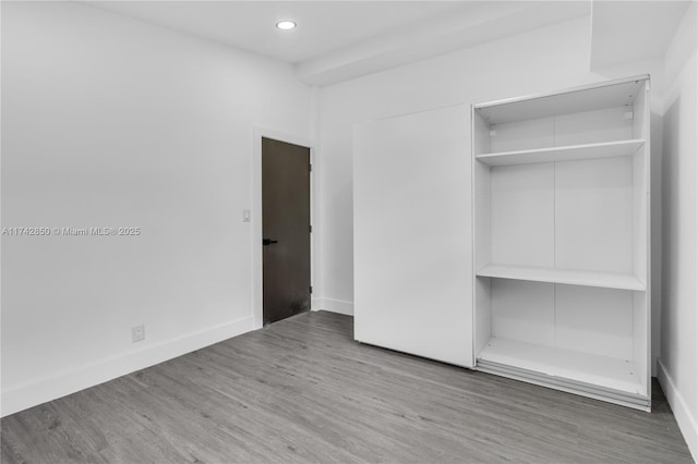 unfurnished bedroom with wood-type flooring and a closet