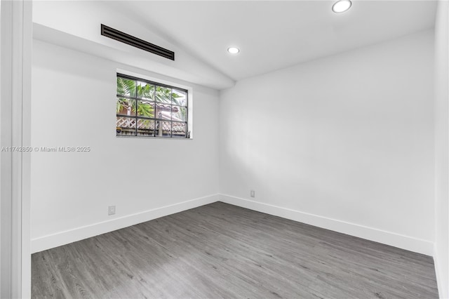 unfurnished room with lofted ceiling and dark hardwood / wood-style flooring