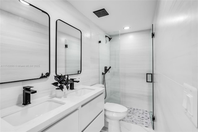 bathroom featuring vanity, tile walls, toilet, and walk in shower