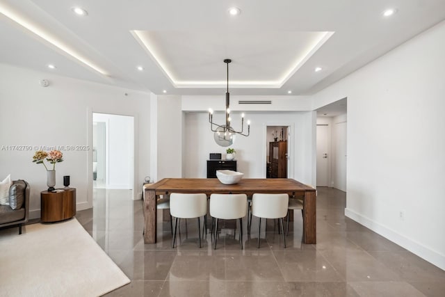 dining room featuring a raised ceiling and a chandelier