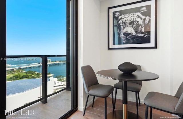 dining room with light hardwood / wood-style flooring and a water view