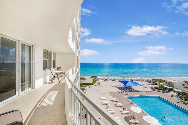 balcony with a water view and a beach view