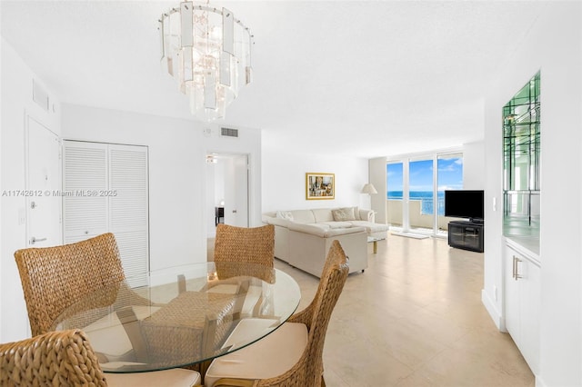 dining area featuring expansive windows and a chandelier