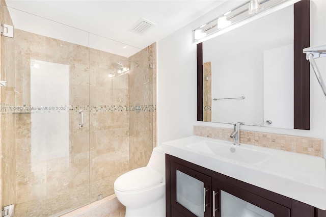 bathroom featuring vanity, toilet, and a shower with shower door