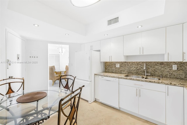 kitchen featuring sink, white appliances, light stone counters, tasteful backsplash, and white cabinets